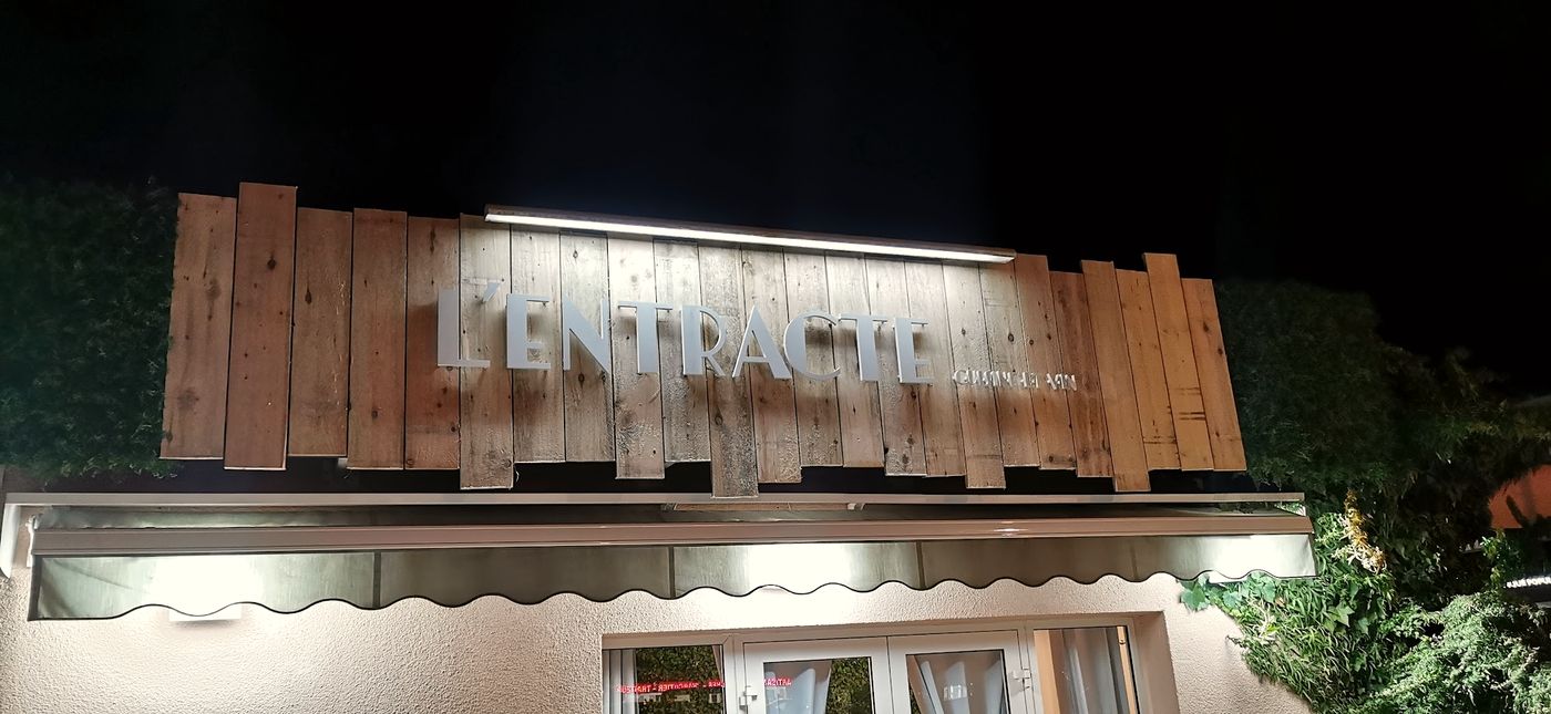 L'enseigne de L'Entracte éclairée la nuit